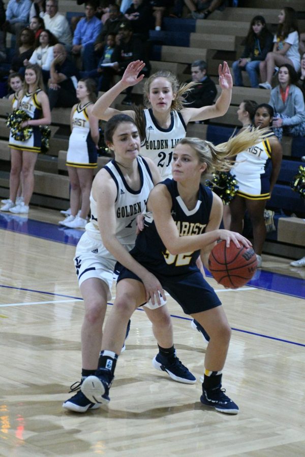 Sophomores Anna Elizabeth Whitlark and Lindsey Broadway defend a Marist player at a home game in December. The team won  41-32, earning their first victory of the season.
