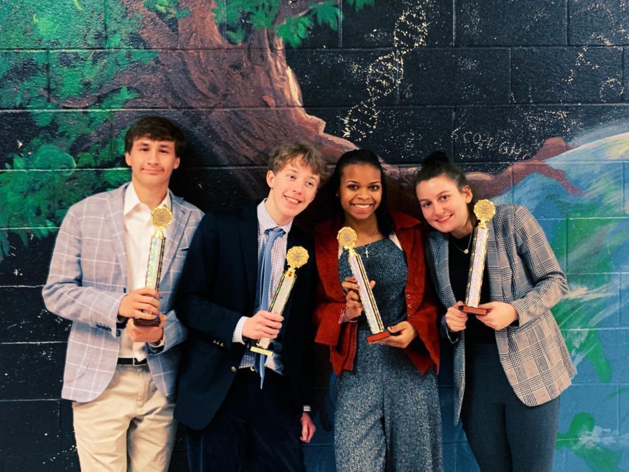 Seniors Austin Lalomia and Witt Hollensbe show off their finalist trophies with two competitors from Walton High School at a competition last year. 