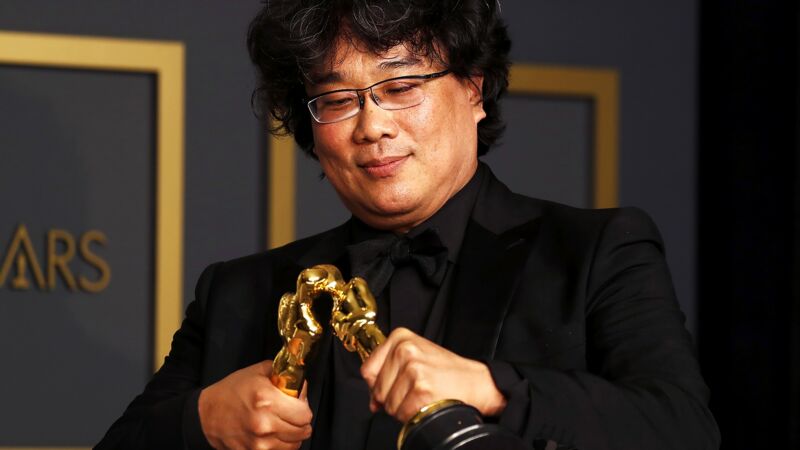 Parasite director Bong Joon-ho celebrates with two of the four Oscar statues his film won at this years Academy Awards
