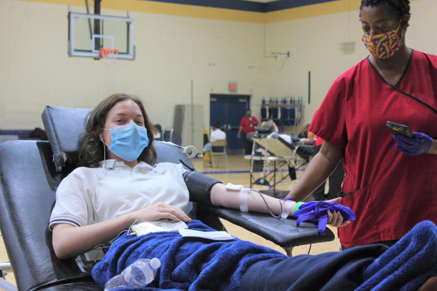 Senior Clara Chase gives blood in the back gym at the Red Cross blood drive in October. St. Pius X collected 100 pints of blood, which will go on to save 300 lives.
