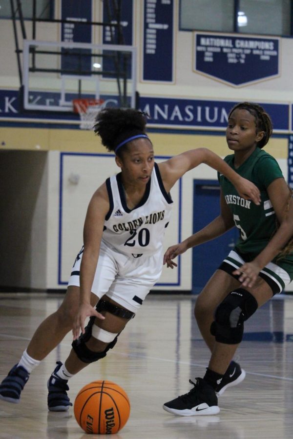 Junior Karis Coleman dribbles past a Clarston defender during a game in February. The team advanced to the second round of the state playoffs this season.