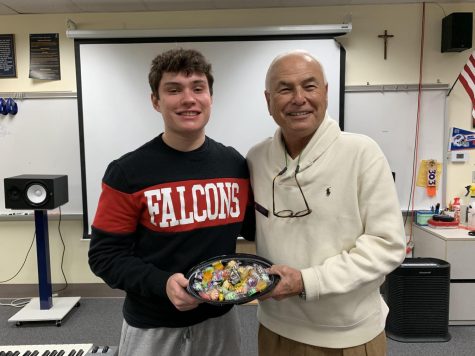 Senior Rain Mason enjoys a treat from Mr. Smiths famous bowl of candy. A former English teacher at St. Pius X, Mr. Smith is now students favorite substitute teacher.