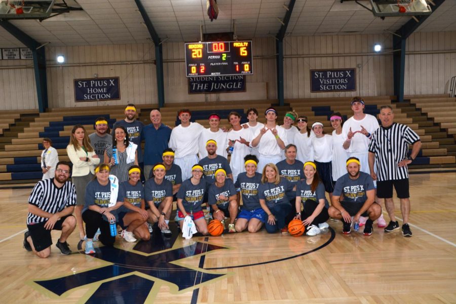 Alumni teachers and seniors gather together for a picture after their basketball game on April 28. The senior team won 20-15.