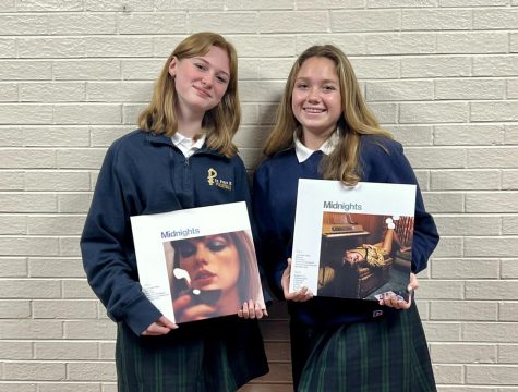 Sophomores Avery Reagan (left) and Elliott Seng hold up their Midnights vinyl albums. 