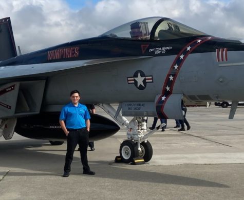 Junior Lyle Pinson stands in front of a fighter Jet. Pinson is the founder of the Aviation Club at St. Pius X and is currently training to become a pilot. 
