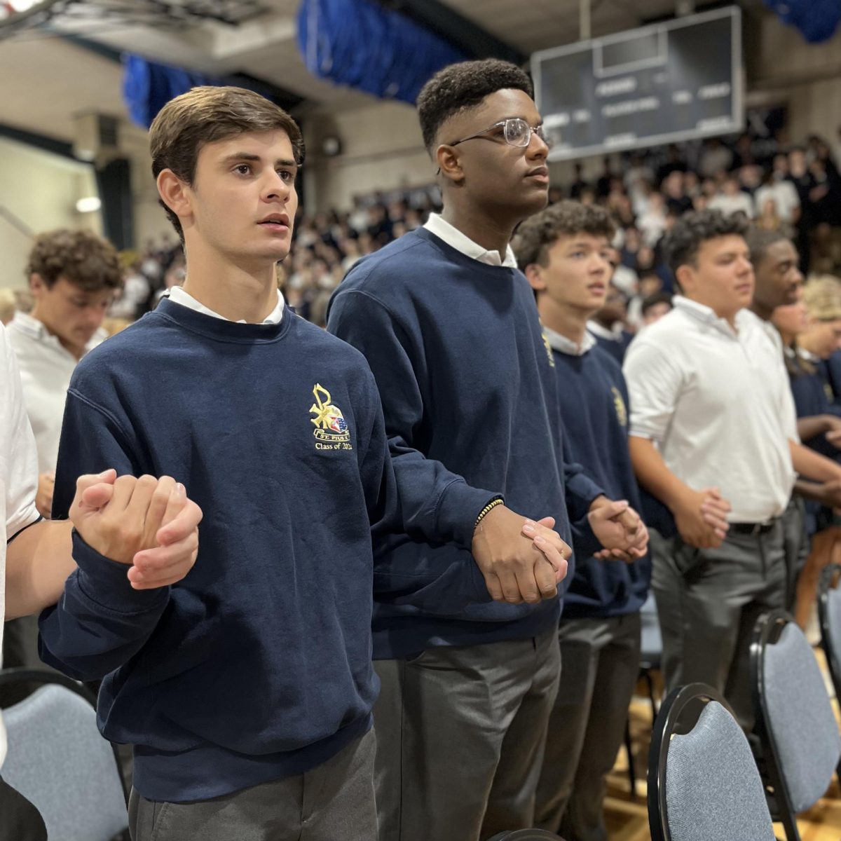 Seniors Porter Messick and Ronnie Stephens say the Our Father during Mass.