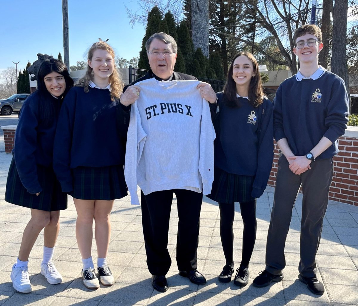 Seniors+Aryana+Wadhwani%2C+Molly+Pitra%2C+Thea+Winckler%2C+and+Shane+Donnelly+take+a+picture+with+the+Papal+Nuncio+while+giving+him+a+tour+of+the+school+in+Fench%2C+his+native+language.