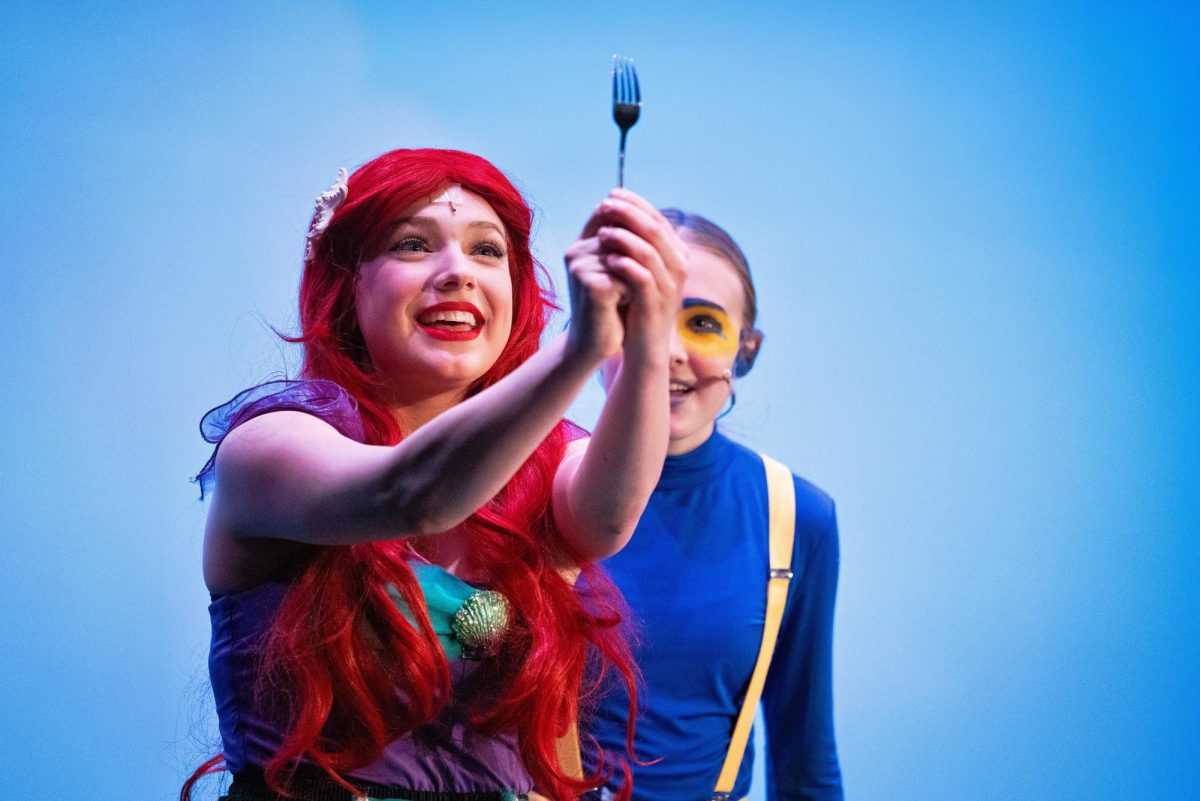 Ariel, played by sophomore Lauren Baker, admires a dinglehopper while wishing she was part of that world as Flounder (senior Emily Kelly) looks on. Photo courtesy of Art of Life