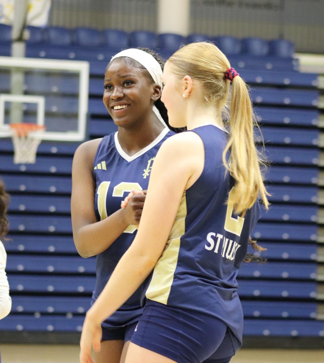Sophomores Lukenya Moleka Fumo and Eveliina Campbell celebrate after scoring a point in a volleyball match against Marist. Campbell said she relies on a Kodiak bar and Alani to get her ready to play.