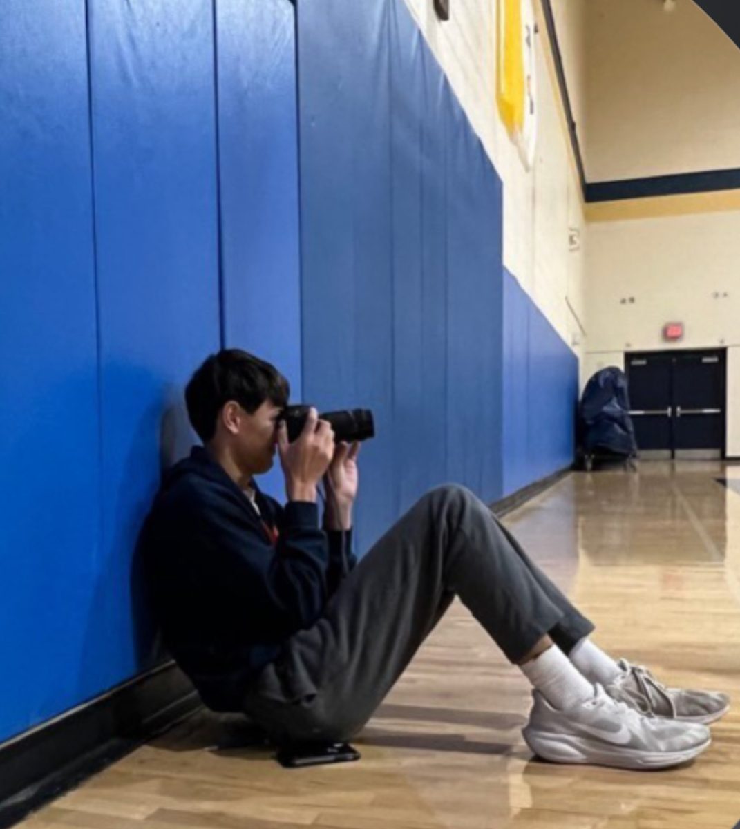 Sophomore Lide Edwards takes photos at a basketball game. Edwards became interested in photography last year, and his classmates often ask him to shoot their athletic events. Photo courtesy of Lide Edwards