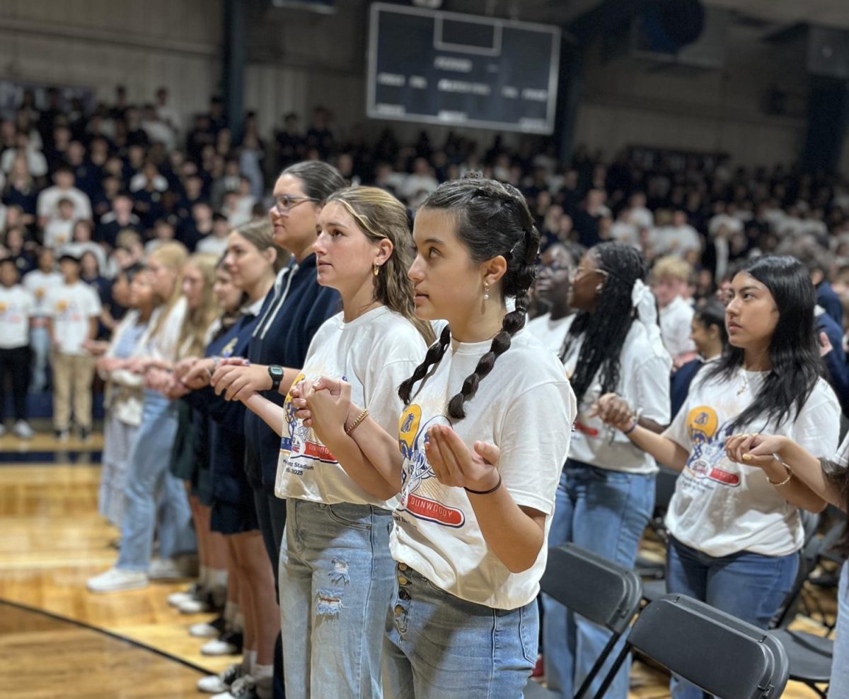 Students pray the Our Father together at mass at the Feast of the Assumption mass in August.